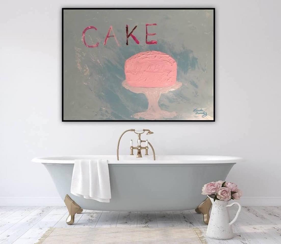 Image of an empty bathtub with a painting of a pink layer cake above.