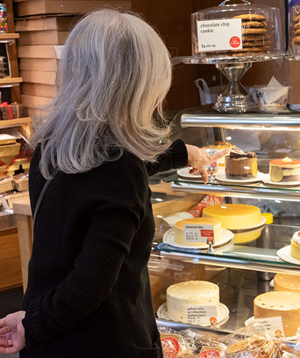 Susan Weiss Berry in a NYC cake shop choosing a cake.